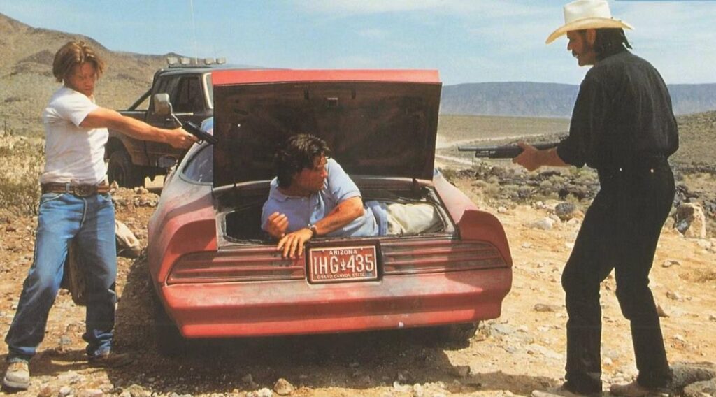 Jeff Taylor (Kurt Russell) stiješnjen u prtljažniku pod cijevima nemilosrdnih lokalnih grabežljivaca.